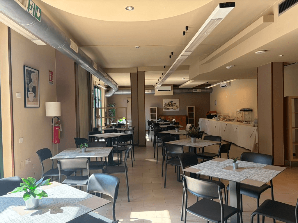 Sala colazione luminosa con tavoli e sedie